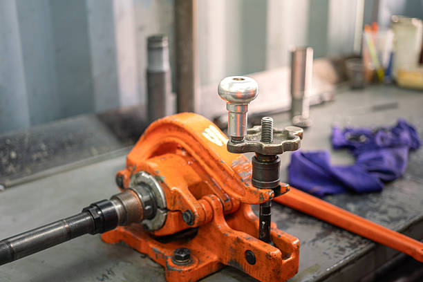 A friction vise grip on metal workbench that using to holding a pipe or special tool for maintenance. Industrial working equipment object, close-up and selective focus.