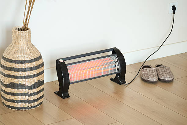 istock Cozy indoor heating setup with heater and comfortable slippers 2218196107