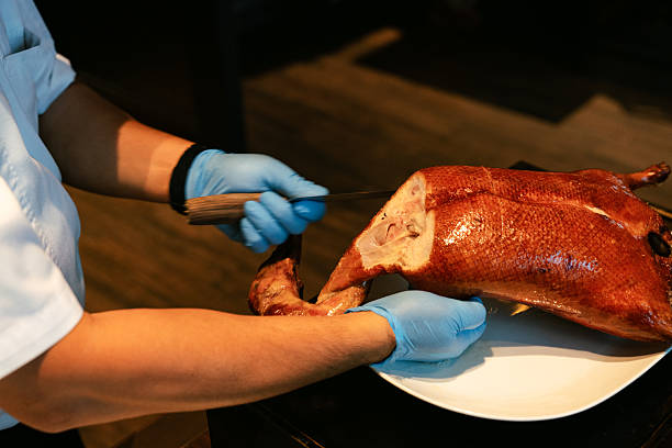 istock Chef Carving Crispy Roasted Duck Leg on White Plate 2218197043