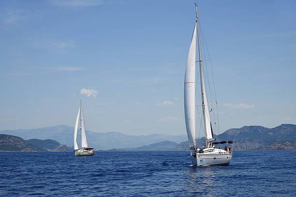 Sailing boats at sea. Water surface and sky in a haze.