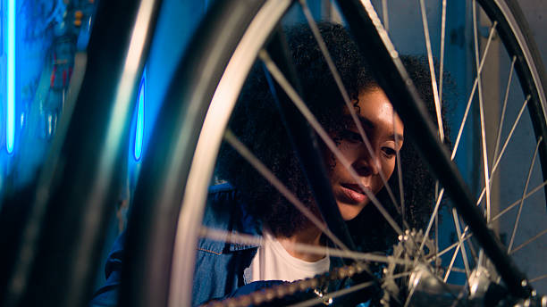 istock Woman Engaged in Bicycle Maintenance Under Blue Neon Lighting 2218198872