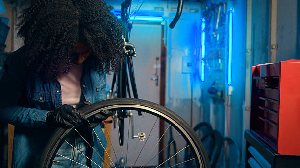 istock Youthful Mechanic Fixing a Bicycle Wheel in a Neon-Lit Workshop 2218198899