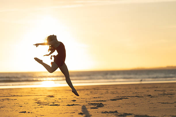 istock Ballerina performing graceful jump on beach at sunset 2218200158