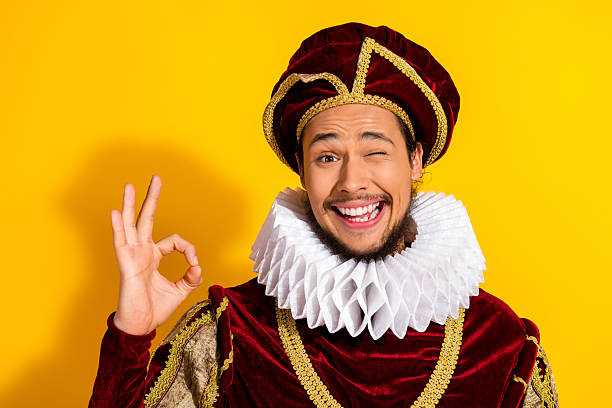 istock Young man in vintage aristocratic costume with yellow background making winking expression 2218202709