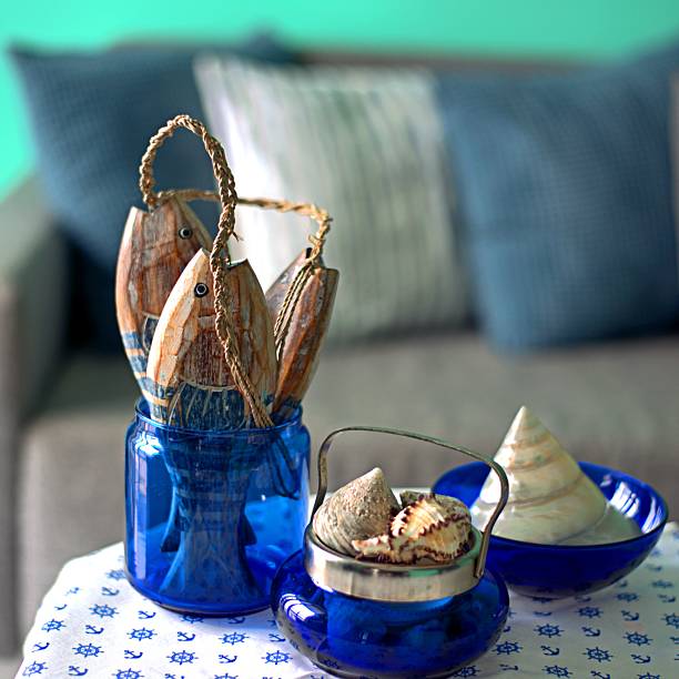 istock Marine style in the apartment interior - a sofa with pillows and a table with shells and fish figures. 2218202859