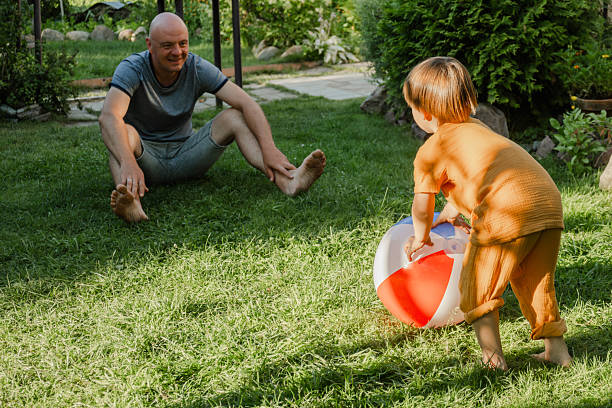 istock Dad and little child playing with inflatable ball in backyard during summer. 2218204437