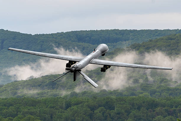 istock Modern technology in action - reconnaissance drone in the air. Heavy UAV with weapons in flight, filmed from behind against the background of picturesque nature. 2218205607