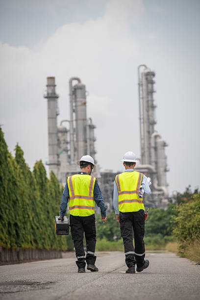 istock Engineers wear safety gear inspecting or document related to plants environment features large industrial chimneys related energy industrial work and environmental monitor carbon credit concept. 2218208613