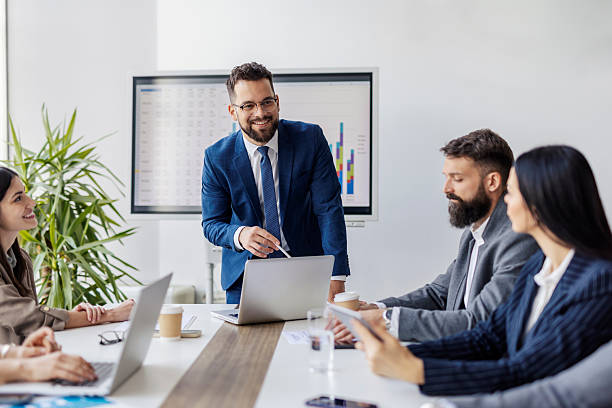 istock Young executive is standing at boardroom with his team of experts and analyzing data and financial reports. 2218217360
