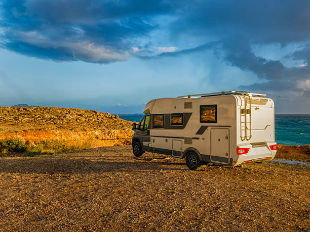 A camper van parked along the stunning coastline of Kalo Nero, Greece, surrounded by scenic cliffs and the ocean.