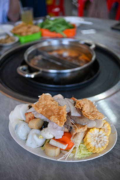 Steamboat buffet ingredients arranged around a hot pot on the dining table