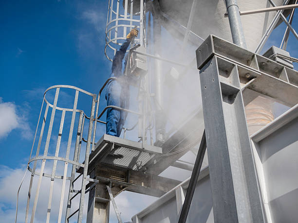 istock Industrial Worker Inspecting Equipment on a Platform Amidst Dust 2218219003