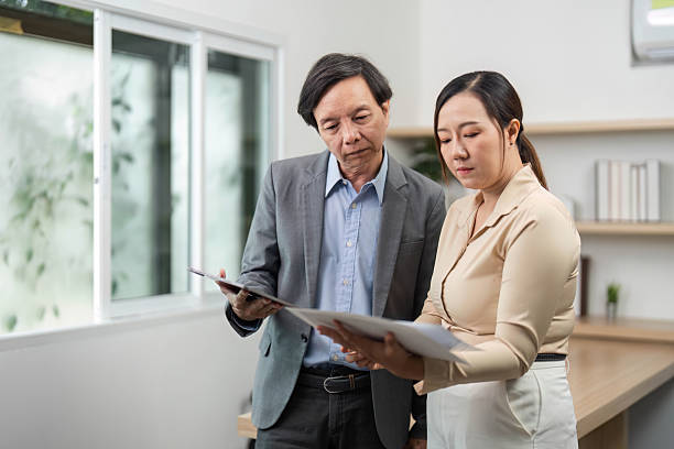 istock Business Collaboration and Professional Discussion. Two colleagues reviewing documents in a modern office. 2218220519