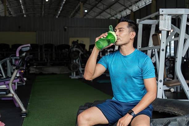 istock Fitness Hydration. A man drinking from a protein shaker in a gym. 2218221006