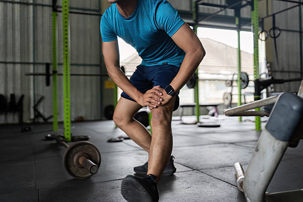 istock Fitness Stretching Routine. Young man warming up before workout in gym. 2218222070