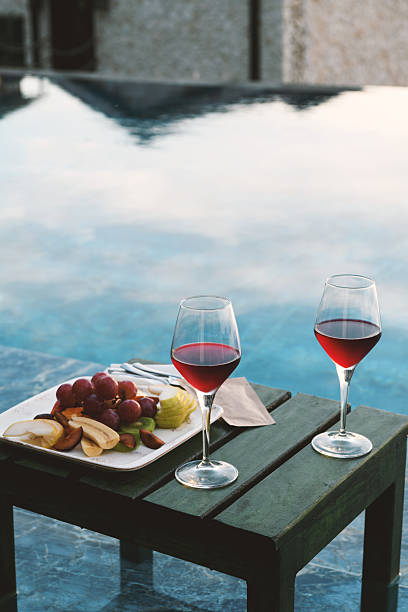 istock Close-Up of Red Wine & Fruit Platter by Pool 2218225250