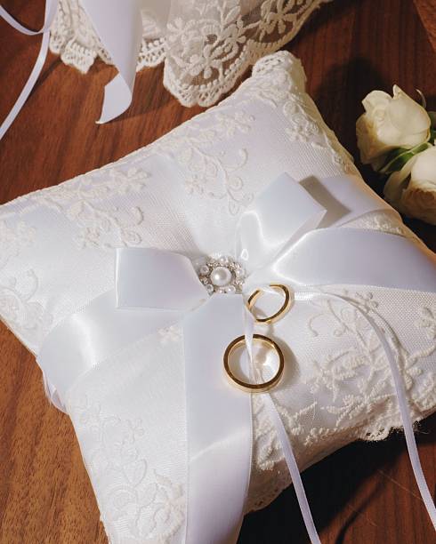 istock Wedding rings on a lace pillow with roses. 2218225402