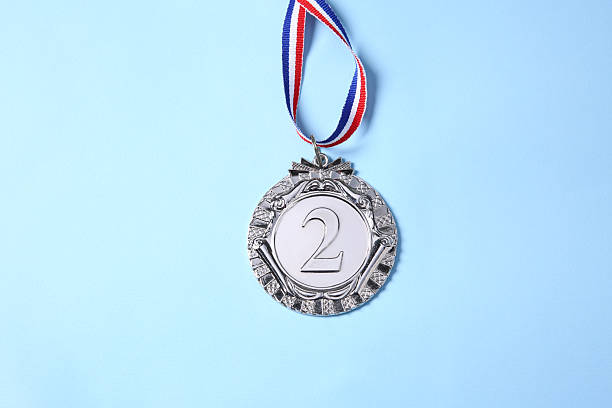 istock One silver medal on light blue background, top view 2218226107