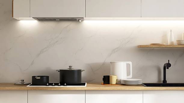 Brown wooden kitchen countertop, white cabinet with induction stove, black sink and cupboard in sunlight on marble wall for interior design decoration, cooking, food, kitchenware product background 3D