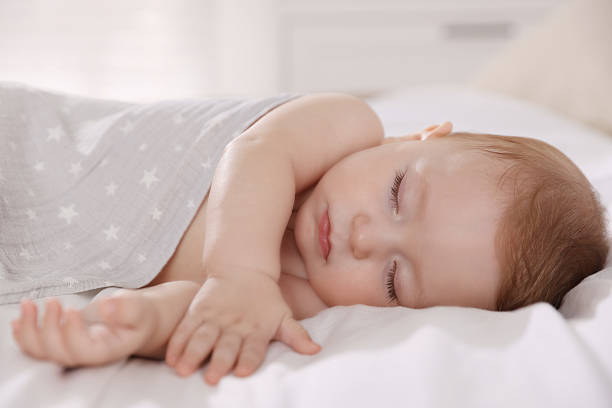 istock Cute little baby sleeping on bed at home 2218228854