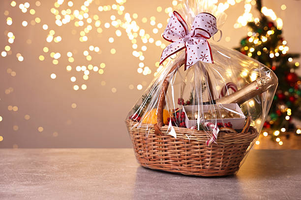 istock Wicker gift basket with sparkling wine and Christmas decor on light grey textured table, space for text 2218229797