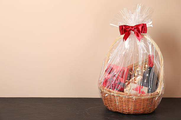 istock Wicker gift basket with wine on black textured table against beige background, space for text 2218229908