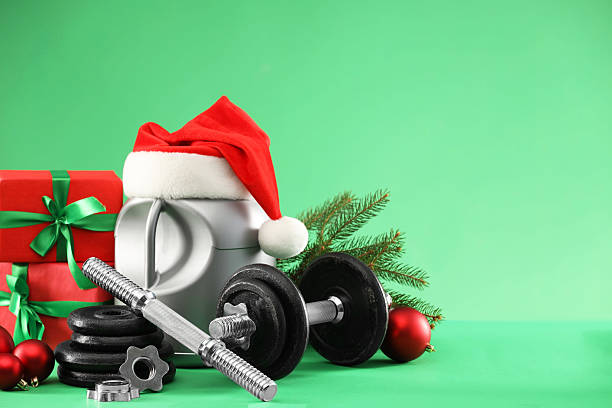 istock Dumbbells, container with supplement and Christmas decor on green background. Space for text 2218230671