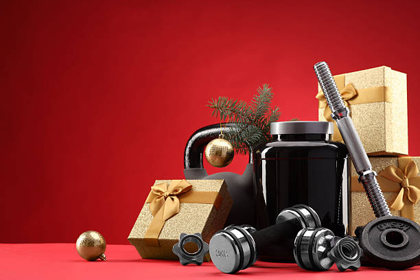 istock Dumbbells, kettlebell, container with supplement and Christmas decor on red background. Space for text 2218230706