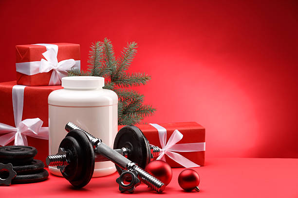 istock Dumbbells, container with supplement and Christmas decor on red background. Space for text 2218230748