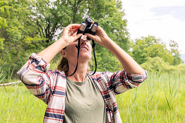 istock Woman Birdwatching in Lush Green Park 2218234233