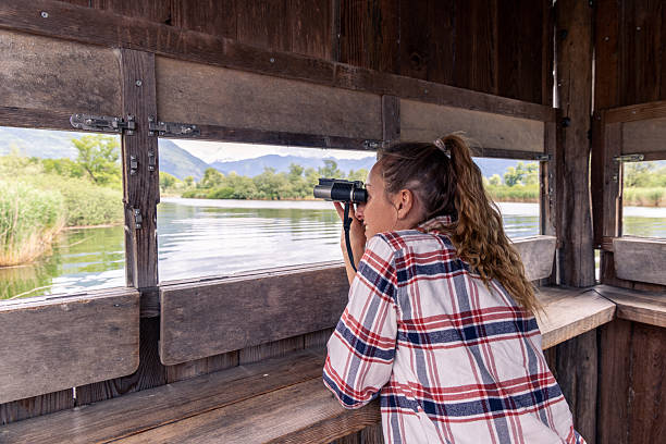 Two Retired Male Friends On Walking Holiday Looking Through Binoculars
