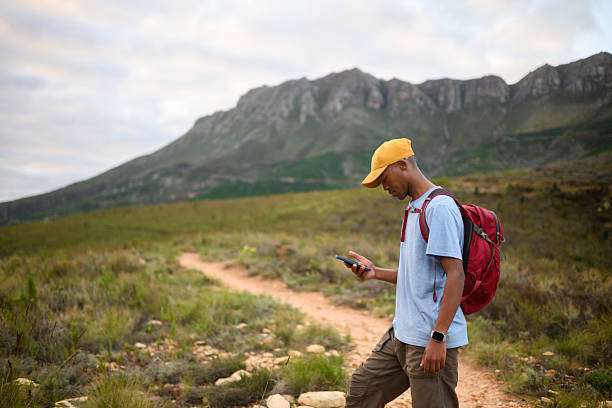 istock Solo male hiker exploring trails on a smart phone looking for direction towards a scenic mountain destination 2218236484