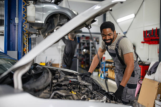 istock Smiling mechanic inspecting car engine with joy 2218237315