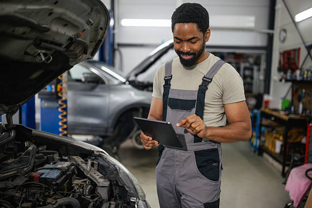 istock Mechanic Working on a Car with Tablet in Garage 2218238321