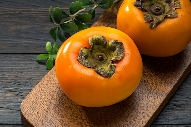 istock Fresh ripe persimmons on wooden table 2218239159