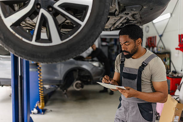 istock Car Mechanic Inspecting Vehicle Underlifted Position 2218241152