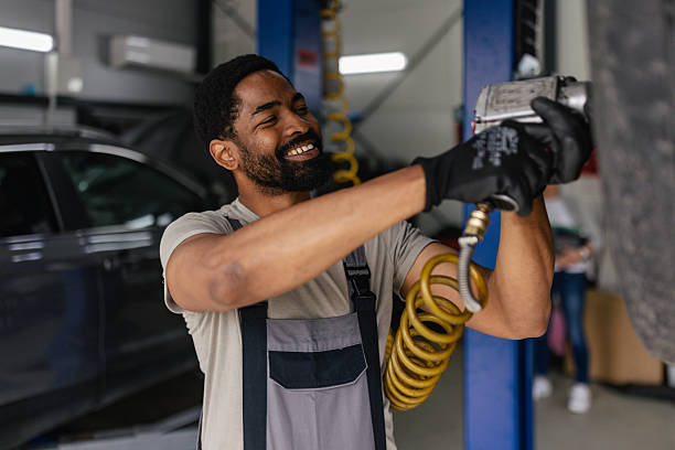 Mechanic joyfully changing tire with air tool