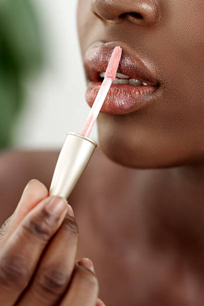 istock Applying lip gloss to enhance beauty during a self-care routine at home 2218252034