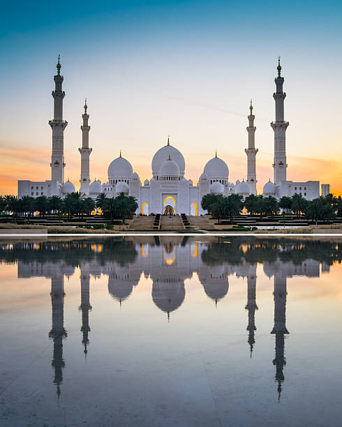 istock Illuminated Sheikh Zayed Grand Mosque with reflections at sunset, Abu Dhabi, UAE. Tourist sightseeing famous grand mosque attraction in United arab emirates. 4k high quality colorful day to night 2218253241