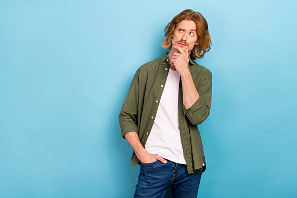 istock Portrait of attractive funky suspicious guy overthinking copy blank space solution isolated over pastel blue color background 2218254913
