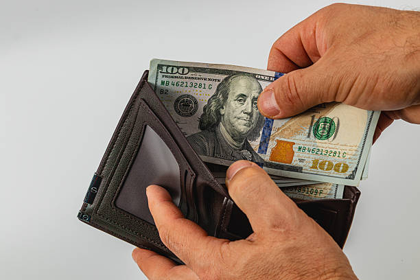 istock Man retrieves cash from wallet during transaction process 2218255040