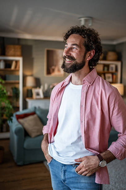 istock Smiling bearded man standing in living room looking away 2218255381