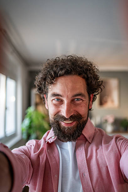 istock Happy bearded man taking a selfie at home 2218255466