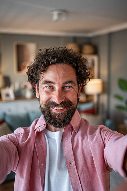 istock Happy bearded man taking a selfie at home smiling at the camera 2218255484