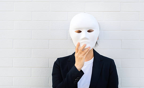 Woman hiding her face behind a white mask