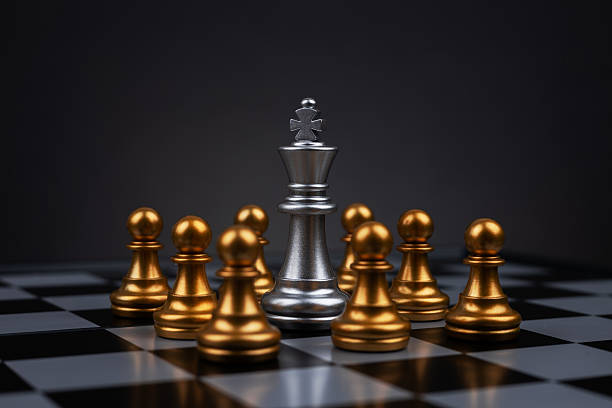 istock White chess king surrounded by black pawns on chess board 2218258309