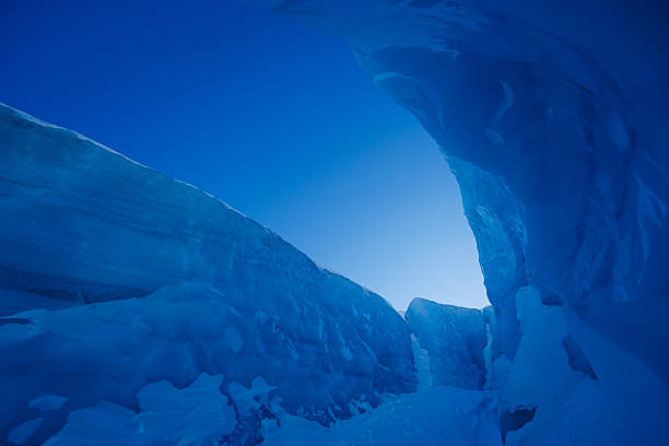 Beauty of the arctic, this pathway is bordered by high walls of blue ice, with a snow-covered track cutting through