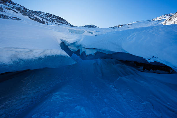 A breathtaking glacier with striking ice formations is depicted in this image against a vividly blue sky