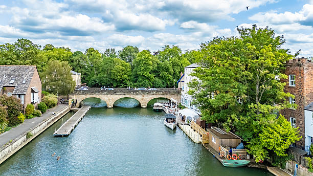 London, UK - 16.01.2024. Richmond bridge is oldest bridge in capital. Moored vessel boats at Richmond Bridge Boat Club at the Thames riverside, south west London. Richmond Bridge is on the background