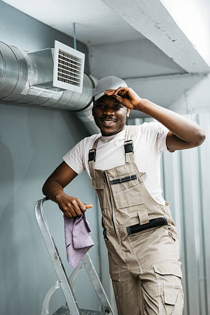 istock Worker smiling while standing on a ladder in a modern workspace during the day 2218265619